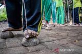 Pelajar bermain permainan tradisional bakiak batok saat Festival permainan tradisional di Kampung Adat Cirendeu, Kota Cimahi, Jawa Barat, Sabtu (7/12/2024). Festival yang diisi dengan berbagai permainan tradisional seperti egrang, bedil jepret, bakiak balok, bedil peletok dan perepet jengkol tersebut digelar untuk melestarikan permainan tradisional, mengasah ketangkasan serta meningkatkan interaksi pergaulan antar anak guna mengurangi penggunaan gawai yang populer dikalangan anak-anak. ANTARA FOTO/Abdan Syakura/agr