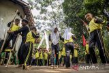 Pelajar bermain permainan tradisional egrang dan bakiak batok saat Festival permainan tradisional di Kampung Adat Cirendeu, Kota Cimahi, Jawa Barat, Sabtu (7/12/2024). Festival yang diisi dengan berbagai permainan tradisional seperti egrang, bedil jepret, bakiak balok, bedil peletok dan perepet jengkol tersebut digelar untuk melestarikan permainan tradisional, mengasah ketangkasan serta meningkatkan interaksi pergaulan antar anak guna mengurangi penggunaan gawai yang populer dikalangan anak-anak. ANTARA FOTO/Abdan Syakura/agr