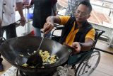 Penyandang disabilitas tuna daksa memasak nasi goreng dalam sesi praktek pelatihan ketrampilan usaha kuliner bertajuk Empower Academy di Malang, Jawa Timur, Sabtu (7/12/2024). Kegiatan tersebut diadakan Ngalup Colaborative Network untuk memberikan ketrampilan serta pendampingan bagi puluhan penyandang disabilitas yang dilakukan secara bertahap selama delapan bulan agar nantinya mereka bisa mendirikan Usaha Mikro Kecil Menengah (UMKM) sektor kuliner. ANTARA Jatim/Ari Bowo Sucipto/mas.