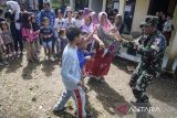 Prajurit TNI AU Lanud Husein Sastranegara menari bersama anak-anak dan orang tua penyintas bencana tanah bergerak saat memberikan layanan trauma healing di Kadupandak, Kabupaten Cianjur, Jawa Barat, Sabtu (7/12/2024). Layanan terapi trauma healing tersebut guna memulihkan dampak psikologis serta meningkatkan semangat bagi anak-anak penyintas akibat bencana geologi tanah bergerak. ANTARA FOTO/Novrian Arbi/agr