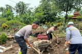 Personel Satlantas Polres Blitar bersama warga membersihkan makam yang rusak akibat banjir bandang di Desa Birowo, Kecamatan Binangun, Kabupaten Blitar, Jawa Timur, Senin (9/12/2024). Banjir bandang yang menerjang sembilan desa di Kabupaten Blitar pada Sabtu (31/11) tersebut merusak fasilitas umum dan makam. Antara Jatim/HO Satlantas Polres Blitar/Um