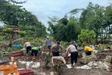 Personel Satlantas Polres Blitar bersama warga membersihkan makam yang rusak akibat banjir bandang di Desa Birowo, Kecamatan Binangun, Kabupaten Blitar, Jawa Timur, Senin (9/12/2024). Banjir bandang yang menerjang sembilan desa di Kabupaten Blitar pada Sabtu (31/11) tersebut merusak fasilitas umum dan makam. Antara Jatim/HO Satlantas Polres Blitar/Um
