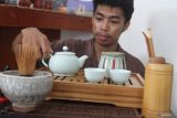 Pengunjung mencoba menggunakan pernak-pernik penyajian teh yang dipajang dalam pameran bertajuk Her Story About Tea di Mason Art Galery, Malang, Jawa Timur, Senin (9/12/2024). Pameran tersebut berlangsung selama dua pekan dan diadakan untuk mengenalkan kepada masyarakat perjalanan industri teh dengan menampilkan puluhan karya berupa lukisan, instalasi, buku sejarah maupun pernak-pernik penyajian teh. Antara Jatim/Ari Bowo Sucipto/um