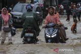 Pengendara sepeda motor melintasi jalan yang terendam banjir di Desa Baros, Kecamatan Baros, Kabupaten Serang, Banten, Senin (9/12/2024). Tingginya curah hujan yang mengguyur kawasan tersebut sejak Senin (9/12) pagi disertai saluran drainase yang buruk mengakibatkan banjir di sejumlah titik dengan ketinggian mencapai sekitar 45 sentimeter. ANTARA FOTO/Angga Budhiyanto/gp