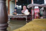 Warga duduk di teras rumah sambil bekerja saat banjir mengenangi Dusun Beluk, Desa Jombok, Kecamatan Kesamben, Kabupaten Jombang, Jawa Timur, Senin (9/12/2024). Dari data BPBD Kabupaten Jombang, banjir akibat luapan avour Watudakon ratusan rumah tergenang banjir dengan ketinggian bervariasi mulai 30 sentimeter hingga 60 sentimeter, selain itu sebanyak 600 jiwa terdampak serta 55 orang mengungsi ketempat aman. ANTARA Jatim/Syaiful Arif/mas.