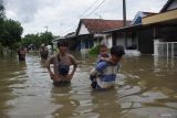 Warga melintasi jalan yang terendam banjir di Dusun Beluk, Desa Jombok, Kecamatan Kesamben, Kabupaten Jombang, Jawa Timur, Senin (9/12/2024). Dari data BPBD Kabupaten Jombang, banjir akibat luapan avour Watudakon ratusan rumah tergenang banjir dengan ketinggian bervariasi mulai 30 sentimeter hingga 60 sentimeter, selain itu sebanyak 600 jiwa terdampak serta 55 orang mengungsi ketempat aman. ANTARA Jatim/Syaiful Arif/mas.