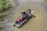 Penyedia jasa menyeberangkan pengendara sepeda motor melewati Jalan Lintas Jambi-Berbak yang terendam air di Gedong Karya, Muaro Jambi, Jambi, Minggu (8/12/2024). Banjir yang terjadi sejak seminggu terakhir akibat meluapnya air Sungai Batanghari di jalan provinsi yang menghubungkan Kabupaten Muaro Jambi dengan Tanjung Jabung Timur itu dimanfaatkan warga sekitar untuk membuka jasa penyeberangan sepeda motor dengan tarif Rp10 ribu per motor. ANTARA FOTO/Wahdi Septiawan/tom.