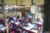 Pelajar kelas 2 mengikuti pelajaran di ruang yang disangga menggunakan bambu agar atap tidak ambruk di SDN Karangpakis 2, Kecamatan Kabuh, Kabupaten Jombang, Jawa Timur, Selasa (10/12/2024). Dua ruang kelas 1 dan 2 di SDN Karangpakis 2, Kabuh, Jombang mengalami kerusakan pada bagian atap sejak setahun terakhir dan disangga dengan bambu agar tidak ambruk sejak sebulan lalu sambil menunggu proses perbaikan dari pemerintah. ANTARA Jatim/Syaiful Arif/mas.