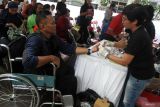 Petugas medis memeriksa kadar asam urat seorang penyandang disabilitas dalam kegiatan Peduli Kota Pengobatan Gratis di jalan Majapahit, Malang, Jawa Timur, Rabu (11/12/2024). Kegiatan tersebut melibatkan ratusan petugas medis yang terdiri dari dokter, perawat serta apoteker dari empat rumah sakit dengan kuota 1.000 orang pasien untuk membantu masyarakat mendapatkan layanan kesehatan secara gratis sekaligus upaya pencegahan penyakit menular jelang meningkatnya mobilitas warga saat natal dan tahun baru. ANTARA Jatim/Ari Bowo Sucipto/mas.