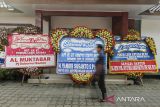 Warga melintas di depan karangan bunga saat ulang tahun Antara ke-87 di Kantor Biro Antara Banten, Kota Serang, Banten, Jumat (13/12/2024). ANTARA FOTO/Putra M. Akbar