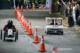 Dua peserta beradu cepat saat mengikuti Lomba Kereta Peti Sabun di ruas jalan Sabuga ITB, Bandung, Jawa Barat, Sabtu (14/12/2024). Lomba Kereta Peti Sabun tersebut diikuti 120 peserta dari warga dan mahasiswa sebagai bentuk ajang pengembangan kreativitas dan inovasi dalam menguji kecepatan sekaligus mengenalkan kembali kegiatan yang sudah populer sejak tahun 1950-an lalu. ANTARA FOTO/Novrian Arbi/agr