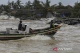 Perahu melayan melintas di perairan Selat Sunda saat gelombang tinggi menerjang di Kecamatan Panimbang, Kabupaten Pandeglang, Banten, Sabtu (14/12/2024). Badan Meteorologi, Klimatologi dan Geofisika (BMKG) mengeluarkan peringatan dini potensi gelombang tinggi di wilayah perairan Banten dengan kisaran 1,25 hingga 2,50 meter yang diperkirakan terjadi di Selat Sunda bagian utara, sedangkan gelombang tinggi dengan ketinggian 2,50 meter hingga empat meter diperkirakan terjadi di Selat Sunda bagian barat, perairan selatan Pandeglang, dan perairan selatan Lebak. ANTARA FOTO/Angga Budhiyanto/gp