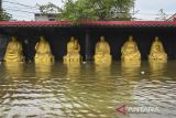 Patung Buddha terendam banjir rob di Kampung Dadap, Kosambi, Kabupaten Tangerang, Banten, Minggu (15/12/2024). Badan Penanggulangan Bencana Daerah (BPBD) Kabupaten Tangerang menyebutkan sebanyak 1.963 jiwa di tiga rukun warga (RW) terdampak banjir rob sejak Jumat (13/12). ANTARA FOTO/Sulthony Hasanuddin/gp