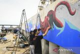 Seniman membuat mural bertema Balada Pesisir di tanggul laut Kampung Dadap, Kosambi, Kabupaten Tangerang, Banten, Minggu (15/12/2024). Pembuatan mural sepanjang 20 meter tersebut untuk menyampaikan aspirasi warga pesisir Kampung Dadap sekaligus mempercantik kawasan tanggul laut. ANTARA FOTO/Sulthony Hasanuddin/gp