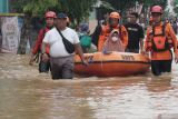 Petugas BPBD menggunakan perahu karet mengevakuasi warga lansia yang menderita sesak nafas dan terjebak banjir di Kelurahan Kelutan, Trenggalek, Jawa Timur, Senin (16/12/2024). Banjir bandang itu menyebabkan jalur utama Trenggalek-Tulungagung putus total dan ribuan rumah di dua kelurahan pusat Kota Trenggalek (Kelurahan Kelutan dan Tamanan) terendam hingga ketinggian air 1,5 meter imbas jebolnya tanggul Sungai Ngasinan pasca turun hujan deras selama beberapa jam sejak Minggu (15/12/2024) malam. Antara Jatim/Destyan Sujarwoko/um