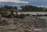 Warga berjalan di atas tumpukan sampah yang terbawa gelombang tinggi di Desa Teluk, Labuan, Kabupaten Pandeglang, Banten, Senin (16/12/2024). Gelombang tinggi yang terjadi di perairan Banten sejak beberapa hari terakhir mengakibatkan sejumlah warung di kawasan pesisir rusak, menumpuknya sampah akibat terbawa gelombang, serta membuat nelayan setempat tidak dapat melaut untuk sementara waktu. ANTARA FOTO/Angga Budhiyanto/gp