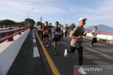 Peserta melintasi jembatan saat mengikuti Fun Run Peringatan  20 tahun Tsunami Aceh di Banda Aceh, Aceh, Minggu (15/12/2024). Pemerintah Aceh menggelar lari santai bertema 