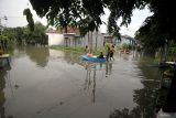 Warga mengevakuasi lansia yang terdampak banjir dengan perahu di perumahan Mutiara Citra Asri, Candi, Sidoarjo, Jawa Timur, Selasa (17/12/2024). Hujan deras yang mengguyur wilayah Sidoarjo selama seminggu terakhir merendam ratusan rumah setinggi sekitar 25 - 50 cm. Antara Jatim/Umarul Faruq