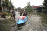 Warga mengevakuasi lansia yang terdampak banjir dengan perahu di perumahan Mutiara Citra Asri, Candi, Sidoarjo, Jawa Timur, Selasa (17/12/2024). Hujan deras yang mengguyur wilayah Sidoarjo selama seminggu terakhir merendam ratusan rumah setinggi sekitar 25 - 50 cm. Antara Jatim/Umarul Faruq