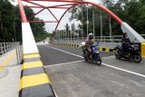 Pengendara motor melintas di jembatan Ngudal, Ngawi, Jawa Timur, Selasa (17/12/2024). Proyek jembatan senilai Rp9,2 miliar tersebut rampung dibangun dan mulai dioperasikan sebagai penghubung menuju jalur wisata ke hutan kota Ngudal serta sentra Usaha Mikro Kecil Menengah (UMKM) sektor kuliner sehingga diharapkan mampu memudahkan akses serta meningkatkan potensi perekonomian masyarakat setempat. ANTARA Jatim/Ari Bowo Sucipto/mas.