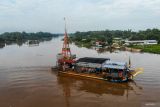 Foto udara perahu penyebarangan melintasi Sungai Brantas di Jatikalen, Nganjuk, Jawa Timur, Selasa (17/12/2024). Transportasi perahu penyeberangan yang digunakan warga sebagai lintasan alternatif selama puluhan tahun untuk mempersingkat jarak tempuh antara Kabupaten Nganjuk dengan Kabupaten Jombang itu beromzet sekitar Rp24 juta per bulannya. ANTARA Jatim/Muhammad Mada/mas.