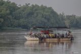 Perahu penyebarangan melintasi Sungai Brantas di Jatikalen, Nganjuk, Jawa Timur, Selasa (17/12/2024). Transportasi perahu penyeberangan yang digunakan warga sebagai lintasan alternatif selama puluhan tahun untuk mempersingkat jarak tempuh antara Kabupaten Nganjuk dengan Kabupaten Jombang itu beromzet sekitar Rp24 juta per bulannya. ANTARA Jatim/Muhammad Mada/mas.