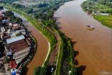 Foto udara perahu penyebarangan melintasi Sungai Brantas di Jatikalen, Nganjuk, Jawa Timur, Selasa (17/12/2024). Transportasi perahu penyeberangan yang digunakan warga sebagai lintasan alternatif selama puluhan tahun untuk mempersingkat jarak tempuh antara Kabupaten Nganjuk dengan Kabupaten Jombang itu beromzet sekitar Rp24 juta per bulannya. ANTARA Jatim/Muhammad Mada/mas.