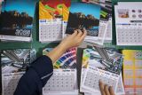 Pekerja menata lembaran kalender 2025 di salah satu industri percetakan di Surabaya, Jawa Timur, Rabu (18/12/2024). Menurut pekerja, produksi kalender meningkat hingga mencapai 2.000 kalender dalam satu bulan terakhir dan dijual dengan harga Rp27 ribu hingga ratusan ribu per kalender. Antara Jatim/Rizal Hanafi/um