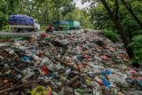 Pengendara melintas di samping tumpukan sampah rumah tangga yang menumpuk di pinggir jalan utama Lamongan Tuban di Baureno, Bojonegoro, Jawa Timur, Rabu (18/12/2024). Kurangnya kesadaran warga dalam membuang sampah pada tempatnya mengakibatkan kawasan jalan tersebut menjadi tempat penampungan sampah yang kotor dan berbau menyengat. Antara Jatim/Muhammad Mada/um