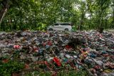 Pengendara melintas di samping tumpukan sampah rumah tangga yang menumpuk di pinggir jalan utama Lamongan Tuban di Baureno, Bojonegoro, Jawa Timur, Rabu (18/12/2024). Kurangnya kesadaran warga dalam membuang sampah pada tempatnya mengakibatkan kawasan jalan tersebut menjadi tempat penampungan sampah yang kotor dan berbau menyengat. Antara Jatim/Muhammad Mada/um