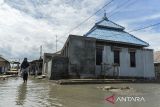 Warga melintasi genangan banjir rob di Kampung Cerocoh, Desa Domas, Kabupaten Serang, Banten, Rabu (18/12/2024). Balai Besar Meteorologi, Klimatologi dan Geofisika (BBMKG) Wilayah II mengimbau warga yang berada di pesisir wilayah Banten untuk mewaspadai terjadinya banjir rob hingga 20 Desember 2024 yang diakibatkan pasangnya air laut. ANTARA FOTO/Putra M. Akbar/gp