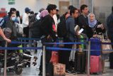 Sejumlah calon penumpang pesawat mengantre untuk lapor diri di Terminal Domestik Bandara Internasional I Gusti Ngurah Rai, Badung, Bali, Rabu (18/12/2024). Pengelola bandara tersebut memprediksi akan melayani sebanyak 1,3 juta orang penumpang selama periode liburan Hari Raya Natal 2024 dan Tahun Baru 2025 dengan perkiraan puncak arus penumpang akan terjadi pada Jumat (20/12). ANTARA FOTO/Fikri Yusuf/wsj.