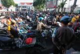 Sejumlah tukang becak antre mendapatkan paket sembako saat Bakti Sosial Bersama Abang Becak di Polrestabes Surabaya, Jawa Timur, Kamis (19/12/2024). Bakti sosial yang digelar dalam rangka 28 Tahun Pengabdian Alumni Akpol 1996 Batalyon Wira Satya itu mengajak sekitar 500 tukang becak makan bersama sekaligus membagikan paket sembako kepada mereka. Antara Jatim/Didik Suhartono/um