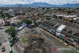 Foto udara alat berat yang dioperasikan petugas meratakan sampah yang menumpuk di Pasar Induk Caringin, Bandung, Jawa Barat, Kamis (19/12/2024). Sampah yang menumpuk berbulan-bulan di Pasar Induk Caringin tersebut disebabkan minimnya ritase angkutan sampah dan warga berharap agar Pemerintah Kota Bandung segera menyelesaikan permasalahan itu karena bau sampah tercium hingga permukiman. ANTARA FOTO/Raisan Al Farisi/agr