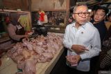 Menko Bidang Pangan Zulkifli Hasan (kedua kanan) membeli daging ayam saat kunjungan kerja di Pasar Dukuh Kupang, Surabaya, Jawa Timur, Jumat (20/12/2024). Dalam kunjungan kerjanya, Menko Bidang Pangan dan Mendag meninjau ketersediaan pasokan dan harga bahan pokok di pasar tradisional jelang Natal dan Tahun Baru 2025. ANTARA FOTO/Rizal HanafiANTARA FOTO/Rizal Hanafi (ANTARA FOTO/Rizal Hanafi)