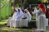 Sejumlah warga berdoa untuk  keluarganya yang syuhada dalam bencana tsunami 26 Desember 2004 bersamaan dengan kegiatan aksi jumat bersih di Kuburan Massal Tsunami, Desa Ulee Lheue, Banda Aceh, Aceh, Jumat (20/12/2024).  Kegiatan ziarah dan berdoa  di kuburan massal itu dalam rangka mengenang dan memperingati  20 tahun bencana Tsunami di Aceh pada 26 Desember. ANTARA FOTO/Ampelsa.ANTARA FOTO (ANTARA FOTO)