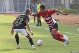 Pesepak bola Madura United FC Taufik Hidayat (kanan) berusaha melewati pesepak bola Bali United FC Novri Setiawan (kiri) pada pertandingan BRI Liga 1 di Stadion Gelora Bangkalan, Jawa Timur, Jumat (20/12/2024). Madura United FC mengalahkan Bali United FC dengan skor akhir 2-1. ANTARA Jatim/Moch Asim.