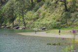 Sejumlah petugas melintas didekat danau Ranu Kumbolo saat meninjau jalur pendakian Gunung Semeru di Lumajang, Jawa Timur, Senin (23/12/2024). Pendakian Gunung Semeru mulai dibuka kembali dengan ketentuan kuota pendakian 200 orang per hari, batasan usia minimal 10 tahun dan maksimal 70 tahun dan hanya sampai di pendakian hingga Ranu Kumbolo. Antara Jatim/Irfan Sumanjaya/um