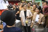 Menteri Komunikasi Digital dan Informasi (Komdigi) Meutya Hafid (kanan) berbincang dengan pedagang kaki lima di Pasar Lama, Kota Tangerang, Banten, Selasa (24/12/2024). Dalam kunjungannya, Meutya Hafid meninjau sejauh mana penerapan digitalisasi yang telah dilakukan para pedagang kaki lima sebagai persiapan merealisasikan target digitalisasi UMKM sebesar 50-60 persen pada 2025. ANTARA FOTO/Sulthony Hasanuddin/gp