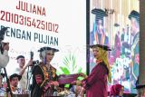 Juliana (kanan) mengikuti prosesi Wisuda ke-6 Universitas Muhammadiyah (UM) Jambi Tahun Akademik 2024/2025 di Jambi, Senin (23/12/2024). Juliana yang berasal dari kelompok Suku Anak Dalam (SAD) Tumenggung Hari dampingan Pundi Sumatra di Bungo berhasil menamatkan pendidikan tingginya di Jurusan Kehutanan, Fakultas Sains dan Teknologi UM Jambi dan menjadi perempuan pertama yang meraih gelar sarjana dari kelompok SAD. ANTARA FOTO/Wahdi Septiawan/rwa.
