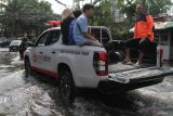 Petugas dari BPBD Jatim mengevakuasi warga menggunakan mobil saat banjir di jalan raya Pepelegi, Waru, Sidoarjo, Jawa Timur, Rabu (25/12/2024). Intensitas curah hujan tinggi di kawasan Waru dan kurangnya normalnya aliran sungai menyebabkan banjir di belasan desa dengan ketinggian air mencapai 30-60 cm. Antara Jatim/Umarul Faruq/um