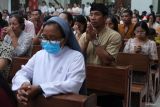 Umat Katolik mengenakan udeng atau ikat kepala khas Bali dalam melaksanakan Misa Malam Natal di Gereja Katolik Paroki Roh Kudus Babakan, Desa Canggu, Badung, Bali, Selasa (24/12/2024). Gereja bernuansa Bali tersebut setiap perayaan Natal sebagian besar umatnya mengenakan busana adat Bali sebagai simbol akulturasi dan pelestarian budaya serta diikuti sejumlah wisatawan mancanegara. ANTARA FOTO/Nyoman Hendra Wibowo/wsj.