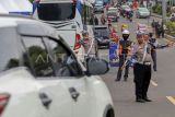 Petugas Sat Lantas Polres Bogor mengarahkan kendaraan wisatawan saat penyekatan kendaraan nomor polisi ganjil genap di jalur wisata Puncak, Gadog, Kabupaten Bogor, Jawa Barat, Rabu (25/12/2024). Kepolisian menerapkan kebijakan ganjil genap di jalur Puncak libur Natal mulai dari tanggal 24 hingga 26 Desember 2024, dan libur Tahun Baru dari tanggal 28 hingga 31 Desember 2024, kebijakan tersebut diambil guna mengantisipasi kepadatan arus kendaraan. ANTARA FOTO/Yulius Satria Wijaya/Spt.