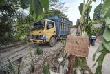 Pengendara melintas di jalan rusak yang ditanami pohon pisang di Kelurahan Pijoan, Muaro Jambi, Jambi, Rabu (25/12/2024). Warga setempat menyebutkan, kerusakan jalan penghubung Kabupaten Muaro Jambi dengan Batanghari tersebut disebabkan meningkatnya mobilitas angkutan pembawa material pembangunan Jalan Tol Tempino-Simpang Ness sejak beberapa bulan terakhir sehingga membahayakan pengendara. ANTARA FOTO/Wahdi Septiawan/foc. 