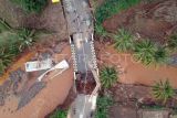 Foto udara jembatan jalur wisata Pelabuhan Ratu - Geopark Ciletuh terputus di Kabupaten Sukabumi, Jawa Barat, Sabtu (7/12/2024). Hujan ekstrem dengan intensitas tinggi dan berdurasi lama yang melanda Kabupaten Sukabumi pada Rabu (5/12), membuat Sungai Cisantri meluap dan mengakibatkan terputusnya jembatan akses wisata menuju Geopark Ciletuh. ANTARA FOTO/Yulius Satria Wijaya/aww.