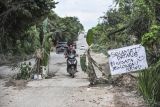 Pengendara melintas di jalan rusak yang ditanami pohon pisang di Kelurahan Pijoan, Muaro Jambi, Jambi, Rabu (25/12/2024). Warga setempat menyebutkan, kerusakan jalan penghubung Kabupaten Muaro Jambi dengan Batanghari tersebut disebabkan meningkatnya mobilitas angkutan pembawa material pembangunan Jalan Tol Tempino-Simpang Ness sejak beberapa bulan terakhir sehingga membahayakan pengendara. ANTARA FOTO/Wahdi Septiawan/foc.