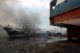 Petugas terperosok saat berusaha memadamkan kapal nelayan yang terbakar di Pelabuhan Tegal, Jawa Tengah, Jumat (27/12/2024). Pemadam kebakaran dan warga kesulitan memadamkan api yang membakar 13 kapal nelayan akibat akses jalan sulit, angin besar dan banyak oli di atas kapal. ANTARA FOTO/Oky Lukmansyah/nym. 