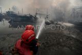 Petugas berusaha memadamkan api saat kebakaran kapal nelayan di Pelabuhan Tegal, Jawa Tengah, Jumat (27/12/2024). Sebanyak 13 kapal nelayan yang bersandar setelah melaut terbakar sekitar pukul 03.00 WIB dan pihak terkait masih menyelidiki penyebab kebakaran tersebut. ANTARA FOTO/Oky Lukmansyah/nym. 