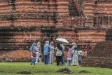 Sejumlah wisatawan mengunjungi Candi Tinggi dalam Kawasan Cagar Budaya Nasional (KCBN) Muarajambi di Muaro Jambi, Jambi, Kamis (26/12/2024). Kawasan situs cagar budaya yang diperkirakan dibangun pada abad ke-6 dan menjadi kawasan pendidikan Buddha terbesar di Asia Tenggara atau seluas 3.981 hektare itu menjadi pilihan sebagian warga untuk memanfaatkan waktu libur Natal 2024 dan Tahun Baru 2025 dengan kunjungan rata-rata per hari 500 orang lebih. ANTARA FOTO/Wahdi Septiawan/YU