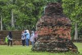 Sejumlah wisatawan berfoto saat mengunjungi Candi Tinggi dalam Kawasan Cagar Budaya Nasional (KCBN) Muarajambi di Muaro Jambi, Jambi, Kamis (26/12/2024). Kawasan situs cagar budaya yang diperkirakan dibangun pada abad ke-6 dan menjadi kawasan pendidikan Buddha terbesar di Asia Tenggara atau seluas 3.981 hektare itu menjadi pilihan sebagian warga untuk memanfaatkan waktu libur Natal 2024 dan Tahun Baru 2025 dengan kunjungan rata-rata per hari 500 orang lebih. ANTARA FOTO/Wahdi Septiawan.